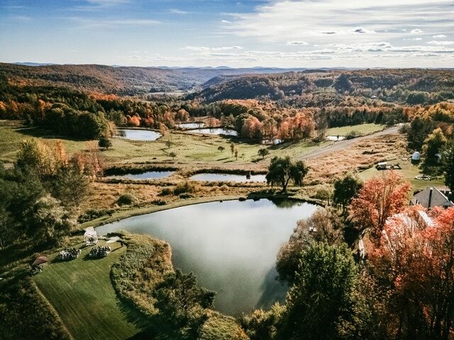 Wide aerial view of the Twelve Ponds property in fall, ponds cascading down the valley.
