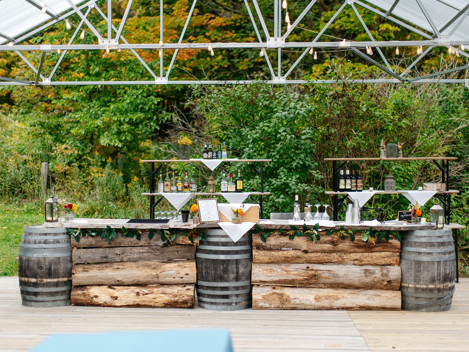 A rustic log-and-barrel bar set up under the pavilion at Twelve Ponds.
